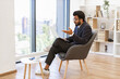 © sofiko14 - An Indian businessman is engaged in a video conference from a modern office setting