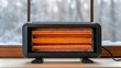 © NoorArt Studio - Electric space heater on a windowsill in winter