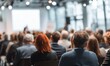 © Strive Studio - Audience members attending a presentation in a brightly lit conference room.