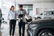 © standret - Business consultation between car dealer and buyer in showroom