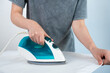 © SVITLANA - Diagonal close-up of a person ironing white cloth. Clean and modern laundry and home maintenance theme.
