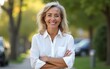 © yuan - Portrait of confident smiling senior female entrepreneur standing outdoors with arms crossed and looking at camera. High quality