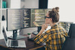 © deagreez - Qualified woman coding at a workstation with multiple monitors in a modern home office workspace