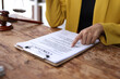 © Wasan - Legal advice concept. Female lawyer reviewing contract documents on wooden table in office.