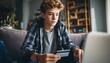 © Andrii - Young Caucasian Male Teenager Utilizing Credit Card And Laptop For Online Shopping And Modern E-Banking Activities From The Comfort Of Home.