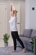 © Pawel - A woman is doing a yoga pose in a living room