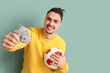 © Pixel-Shot - Happy young man with soccer ball and money on green background. Sports bet concept
