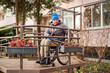 © Alex - A man in a wheelchair stopped on a ramp and looked at flowers.