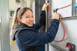 © pacoocimage - Woman electrician installing wires in electrical panel