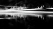 © graphicview35 - Abstract black and white photograph capturing motion blur over dark water creating horizontal streaks of light and reflection in a dramatic, highcontrast scene