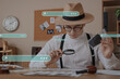 © Pixel-Shot - Male detective with magnifier investigating case at table in office