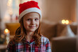 © Halfpoint - Portrait of small girl with Santa hat indoors at home at Christmas, looking at camera.