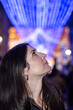 © FotoAndalucia - Informal Portrait of a Woman Looking at Christmas Lights in a European City on a Winter Night