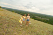 © Mariia - Family on a meadow, mother and daughter holding hands while carries picnic basket