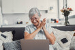 © Daniel - Elderly woman celebrates while using her computer at home after a successful online purchase. She feels cheerful and euphoric enjoying her digital victories.