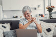 © Daniel - Elderly woman celebrates while using her computer at home after a successful online purchase. She feels cheerful and euphoric enjoying her digital victories.