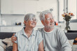 © Daniel - Happy senior couple relaxing together at home on sofa, elderly retired woman and partner looking out the window while sharing a calm moment, enjoying peaceful domestic life and emotional connection