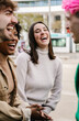 © Xavier Lorenzo - Young multiracial group of friends laughing during casual meeting. Diverse group enjoying spontaneous fun while standing together outdoors. Social connection concept.