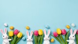 Easter bunny figurines and colorful eggs arranged with tulips for seasonal greeting design