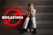 © New Africa - Stop bullying. Sad little girl with toy bunny crying on stairs indoors. Prohibition sign with word