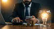© shadab - Businessman with lightbulb idea and coins on desk