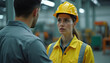 © Vadym - Woman industrial worker in yellow hard hat talks to male colleague in factory. Female employee looks concerned facing coworker at manufacturing plant. People work on production line.