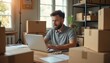 © Pete - Man works on laptop surrounded by boxes. Entrepreneur prepares online orders for shipping. Small business owner manages inventory for e-commerce fulfillment from home office.