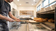 © D-stock photo - Baker in a bakery holding a wooden spatula and preparing fresh bread