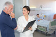 © auremar - young female doctor talking to senior patient at the hospital