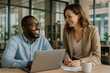 © thodonal - Two professionals collaborating in a modern office setting
