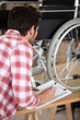 © auremar - young man repairing wheelchair in his office