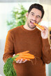© auremar - man eating carrots in modern kitchen