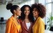 © Matthew - Three diverse women smile together in a bright modern office The women are dressed in colorful outfits and are standing close to each other showcasing their camaraderie and friendship. High quality