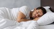 © Eddie Hsieh - A peaceful young man is sleeping soundly in a comfortable white bed