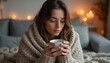 © Maryna - Young woman wraps in warm beige knit blanket holding ceramic mug with hot beverage. Cozy indoor scene with soft diffused lights creates peaceful mood.