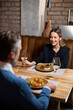 © BGStock72 - Couple enjoys dinner at restaurant with dishes and wine on a cozy evening