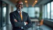 © Maryna - Smiling African American businessman in formal suit poses with crossed arms in office. Mature confident CEO with eyeglasses and grey hair looks at camera.