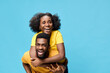 © SHOTPRIME STUDIO - Happy couple in matching yellow outfits laughing together against a bright blue background, showcasing joy and connection in a playful moment