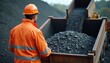 © Maryna - Man in orange hi vis jacket and hard hat watches truck load gravel or ore. Worker supervises mining transport operation, material processing at quarry site.