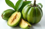 Green garcinia cambogia fruit whole and sliced with leaves on white background. Natural superfood for diet and health wellness concepts. Exotic tropical ingredient for supplements.