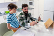 © Antonio Recena - father and son doing homework and using tablet at home