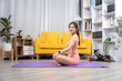 © Kritdanai - Serene Yoga Session: A woman meditates on a yoga mat within a contemporary living space, embodying tranquility and healthy living.