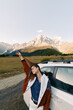 © SHOTPRIME STUDIO - Woman by white car near mountain range on roadside, travel and roadtrip scene with adventure spirit and freedom, casual jacket, scenic landscape and outdoor exploration.