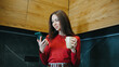 © tol_u4f - Young woman enjoying coffee while using smartphone in modern kitchen environment during morning hours