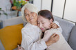 © Charlie's - portrait of grandmother with granddaughter  family leisure sits on couch at home