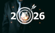 © PRIM - Businessman holding piggy bank with 2026 target icon. Concept of financial goal setting, saving money for future, investment strategy success, and corporate wealth management planning.