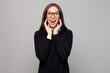 © ViDi Studio - Young employee business woman corporate lawyer she wear black sweater shirt work in office scream sharing hot news about sales discount with hands near mouth isolated on plain grey color background.
