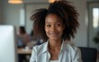 © Gary - Black girl in office in foreground is looking at camera. High quality