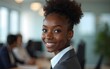 © Gary - Black girl in office in foreground is looking at camera. High quality