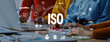 © InfiniteFlow - Team members engage in a collaborative discussion on ISO standards while analyzing data, charts, and documents in a modern office setting. Trope